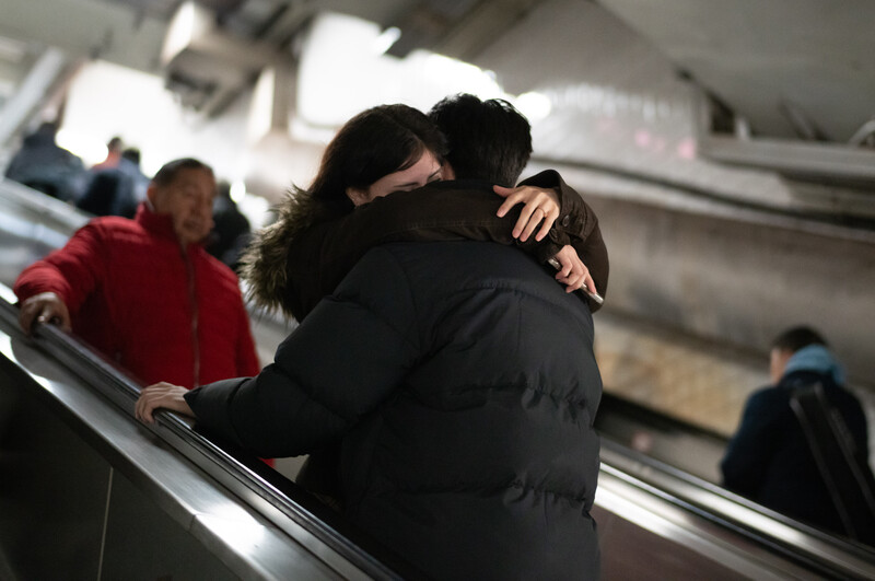 Couple embracing in a subway station.