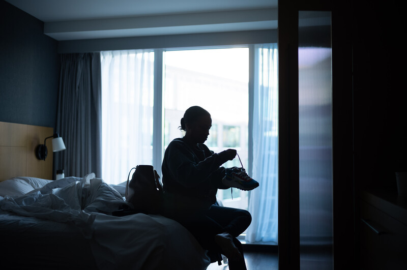 Woman putting on shoes in silhouette 