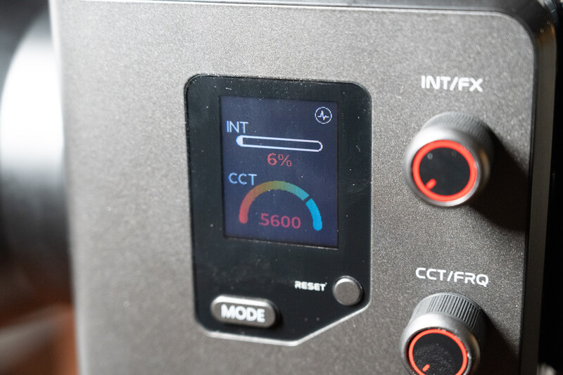Close-up of a lighting control panel displaying color temperature and intensity settings on a small LCD screen.