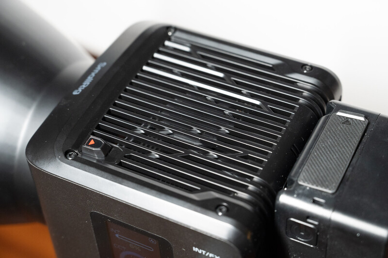 Close-up of a camera flash unit's reflector panel showing horizontal ribbed lines and metallic finish.