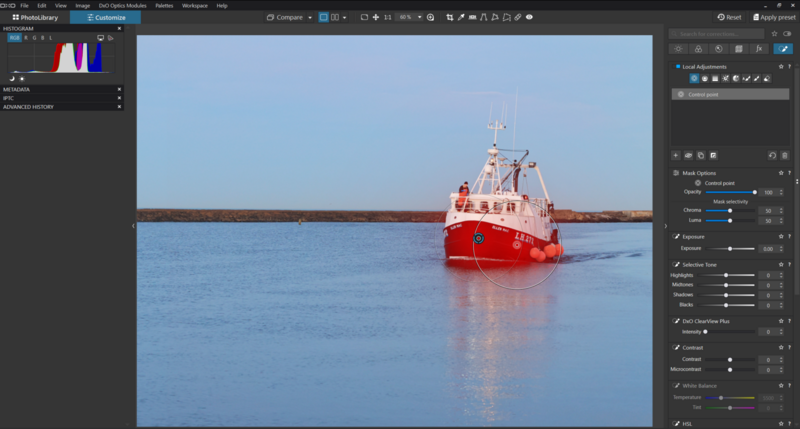 Red and white vessel on frozen water with dark shoreline in background under clear sky.