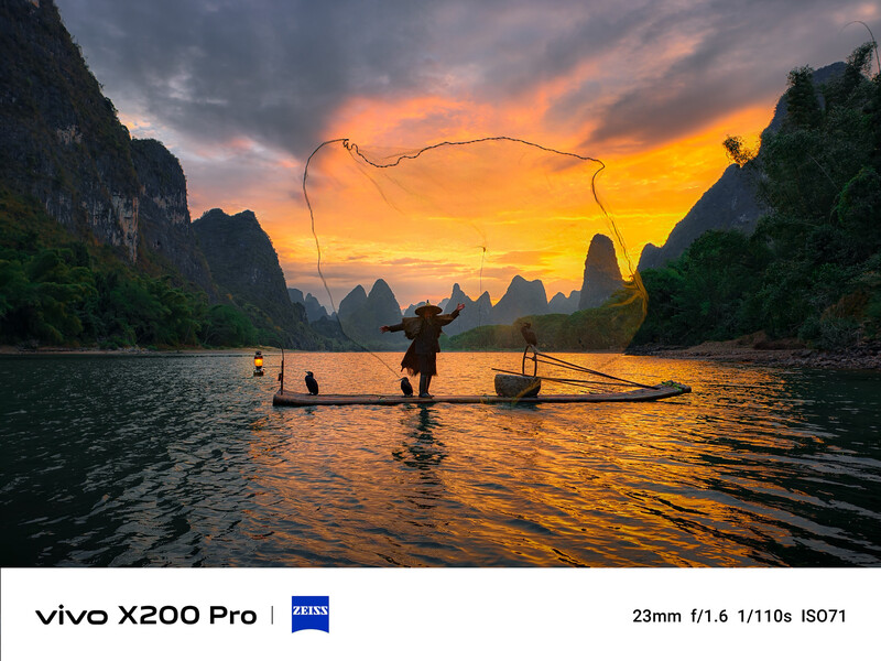 Fisherman casting net at sunset on river surrounded by dramatic limestone peaks.