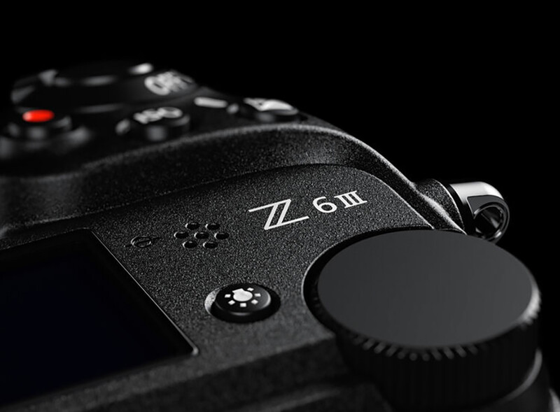 Close-up of a camera body showing a 50mm lens mount and control dial against a black background.