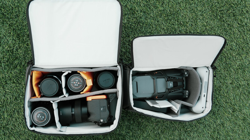 Two white hard cases with custom foam inserts displaying camera lenses, a drone, and photography accessories organized in compartments.