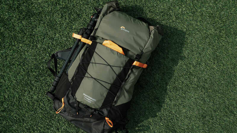 Overhead view of a hiking backpack with gray and black panels and orange accents on artificial turf.