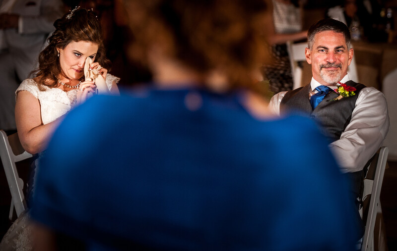 Couple reacts to toast as an example of wedding photojournalism