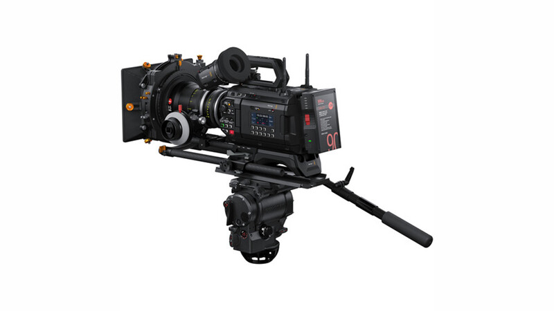 Professional cinema camera mounted on a fluid head tripod with wireless monitoring system and follow focus equipment attached.