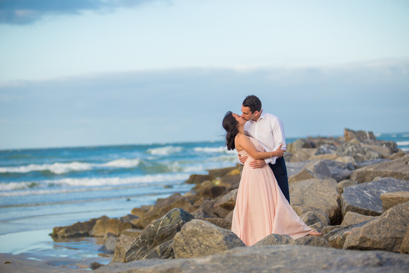 Beach weddings photographer captures portrait of a couple on rock jetty at smyrna dunes park 