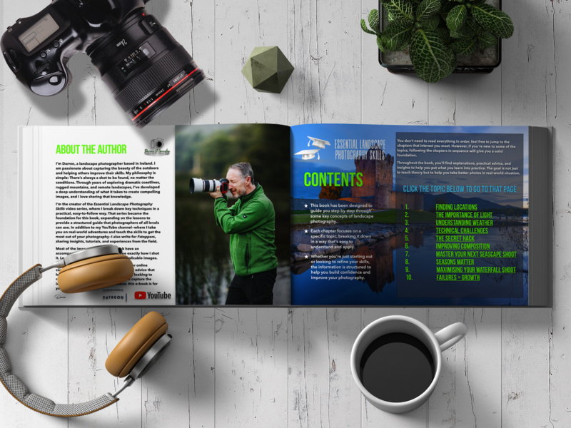 Flat lay of photography equipment and an open magazine spread on a white wooden surface.