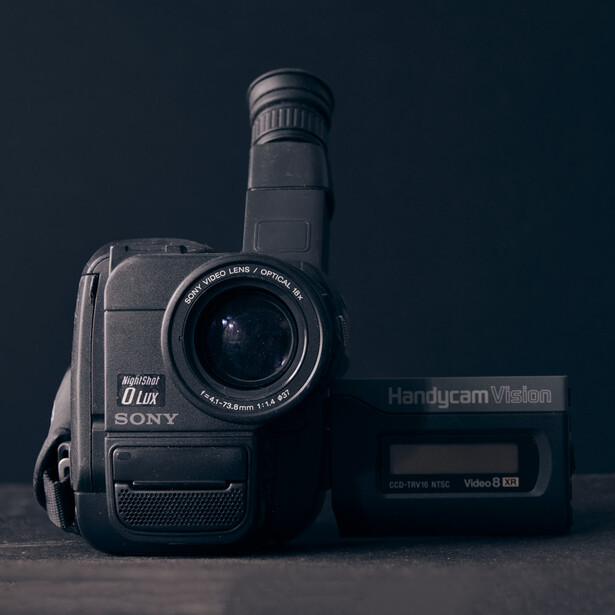 Sony Handycam camcorder with extended telephoto lens on dark background.