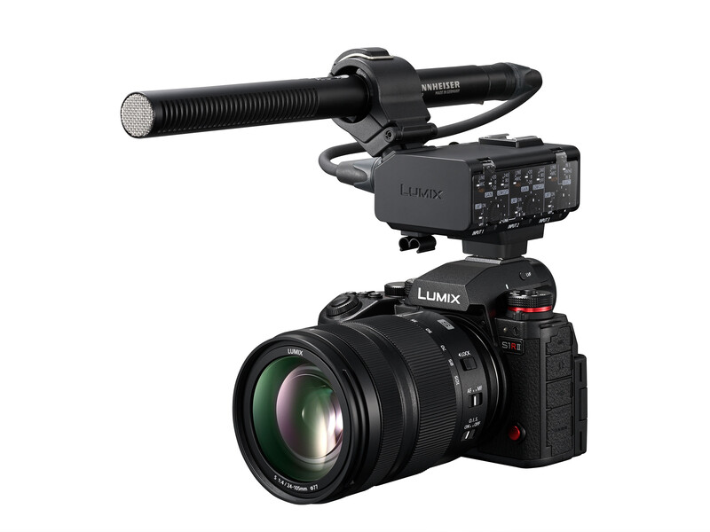 Professional cinema camera setup with external audio recorder and shotgun microphone mounted on top.