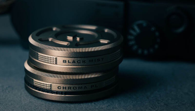 Stacked camera lens filters with engraved text bands showing various filter types.