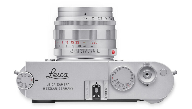 Top-down view of a Leica rangefinder camera with mounted lens, showing aperture and shutter speed dials.