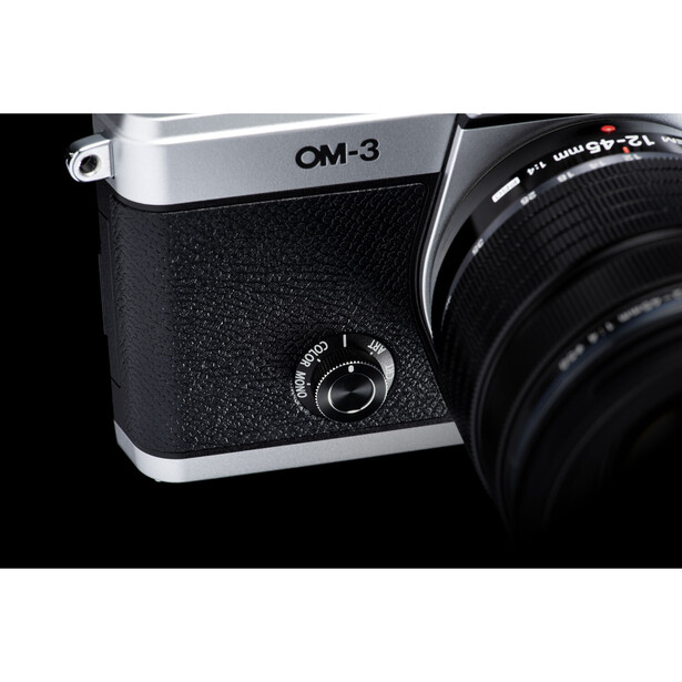 OM-3 rangefinder camera with black leather grip and attached telephoto lens against dark background.