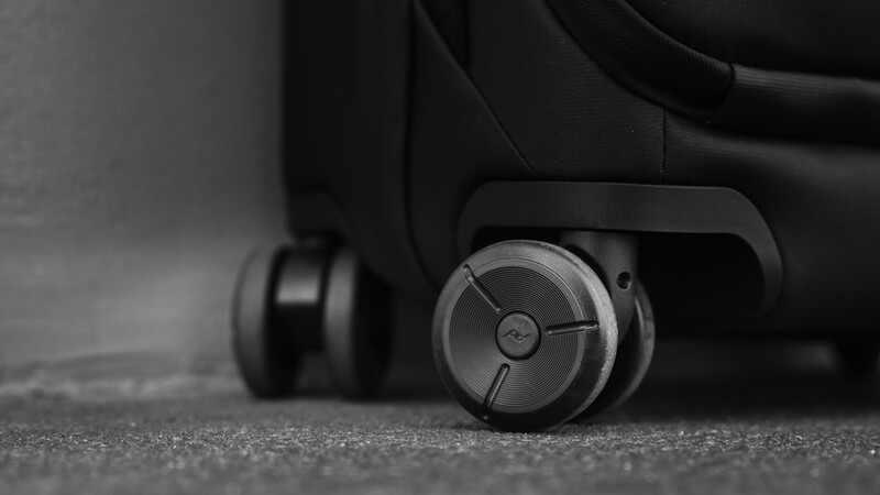 Close-up of office chair caster wheels on gray carpet, shot from low angle in black and white.