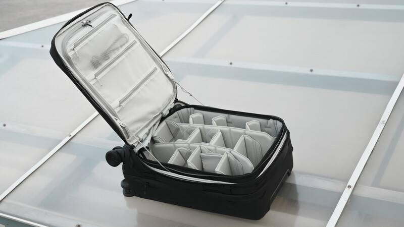 Black camera gear case with customizable fabric dividers displayed open on a white surface.