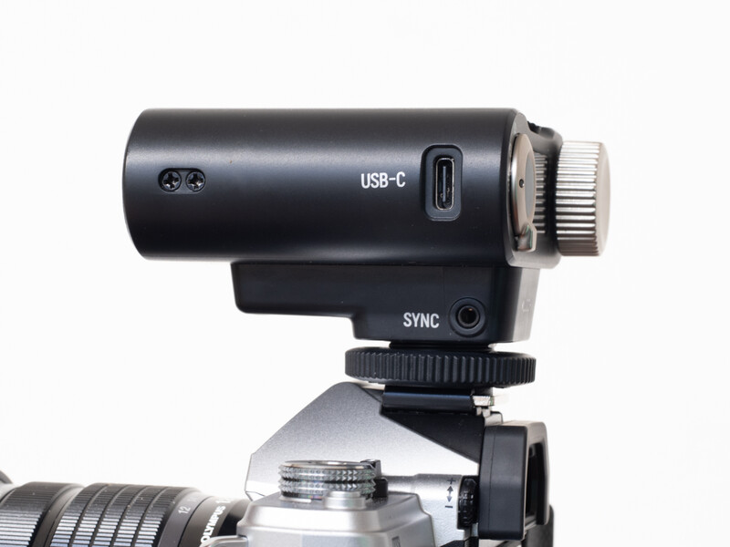 Black USB-C powered camera microphone mounted on a hot shoe with sync port visible.
