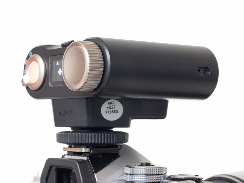 Black camera-mounted LED light with diffuser dome and control knobs on tripod head.
