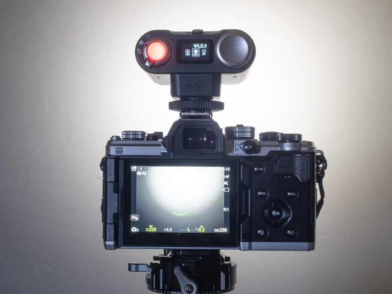 Mirrorless camera with articulating screen mounted on tripod, topped with dual-monitor external recording device.