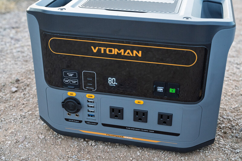 VTOMAN portable power station with solar input and multiple AC/USB outlets displayed on concrete surface.