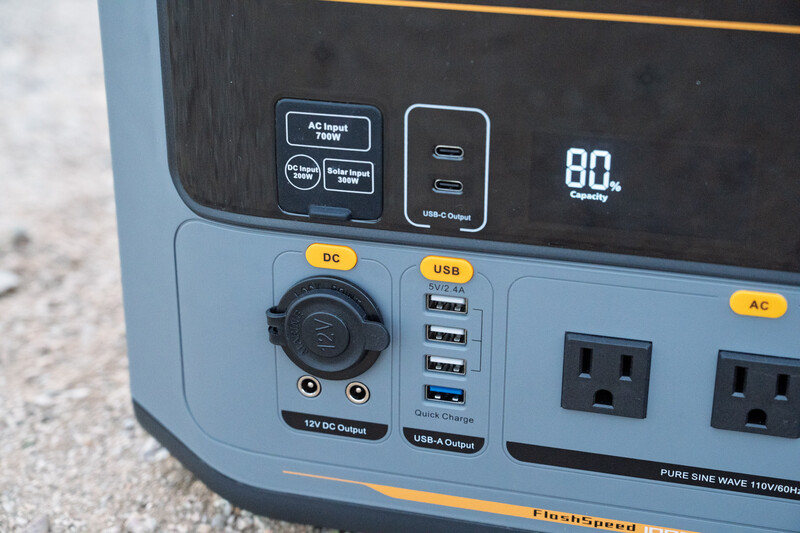 Close-up of a portable power station's front panel showing DC, USB, and AC outlets with a digital display indicating 80% battery capacity.