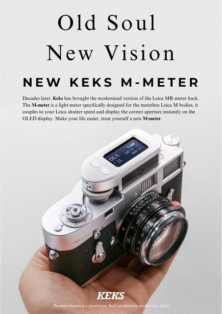Hand holding a vintage rangefinder camera with a modern digital display mounted on top.