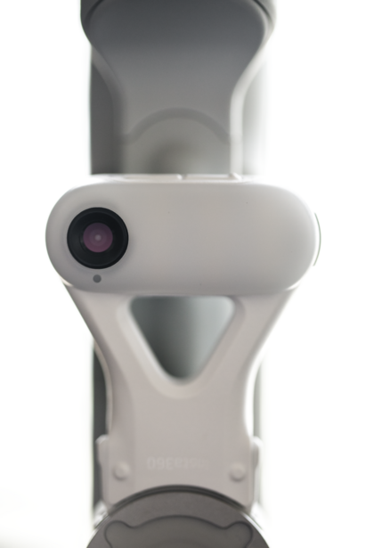 White and gray gimbal stabilizer with mounted smartphone and camera lens visible at bottom.