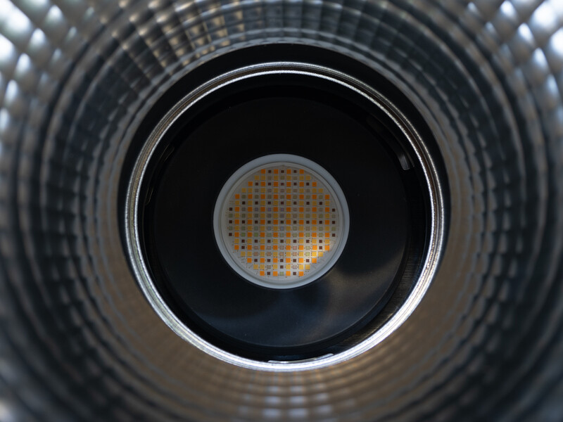 Looking down through concentric circular metal rings toward a small perforated disc at the center point.