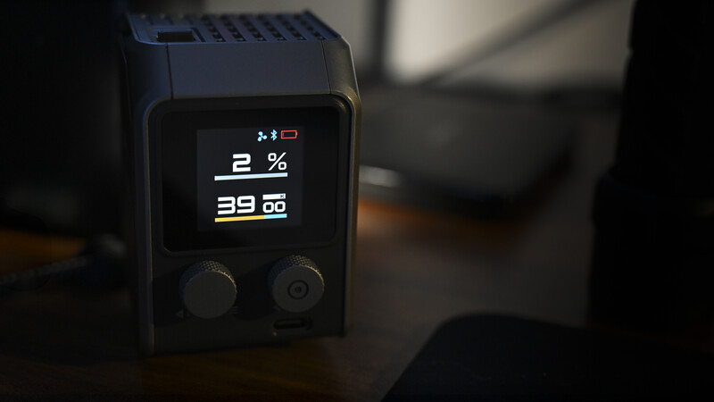 A compact wireless flash unit displaying 2% battery charge and 39.00 on its small LCD screen.