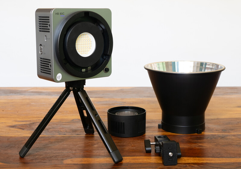 Professional LED light kit with reflector and accessories arranged on wooden surface.