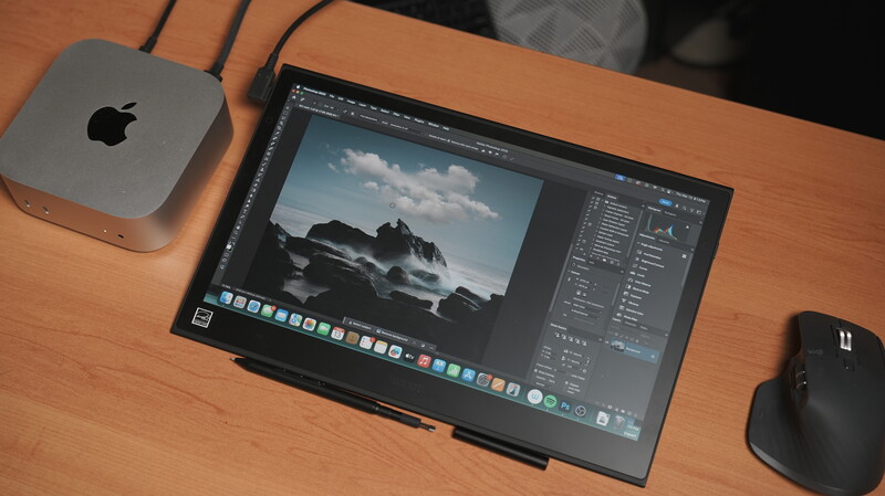 Mac mini connected to external monitor displaying photo editing software with landscape image and adjustment panels.