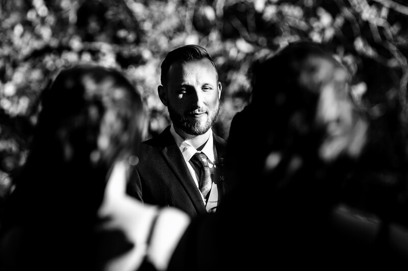Groom stands in dappled lighting for hard light photography tips example