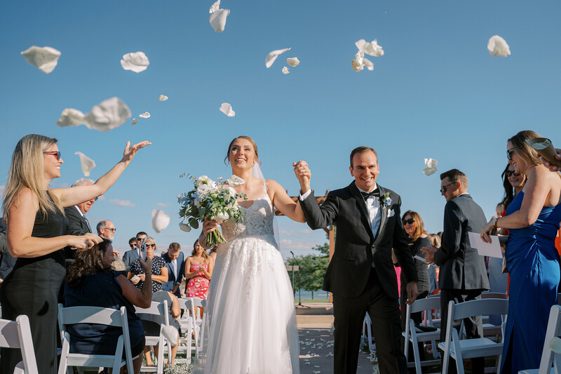 bride and groom hold hands during recessional 
