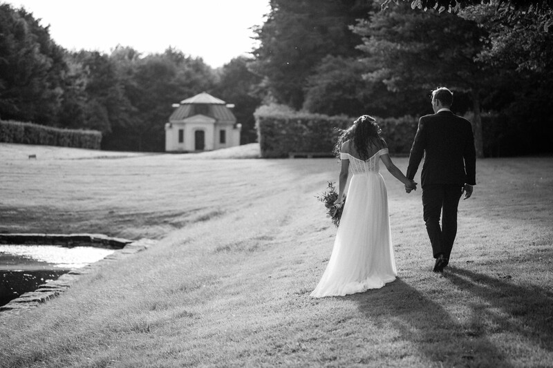 Bride and groom walk on a lawn