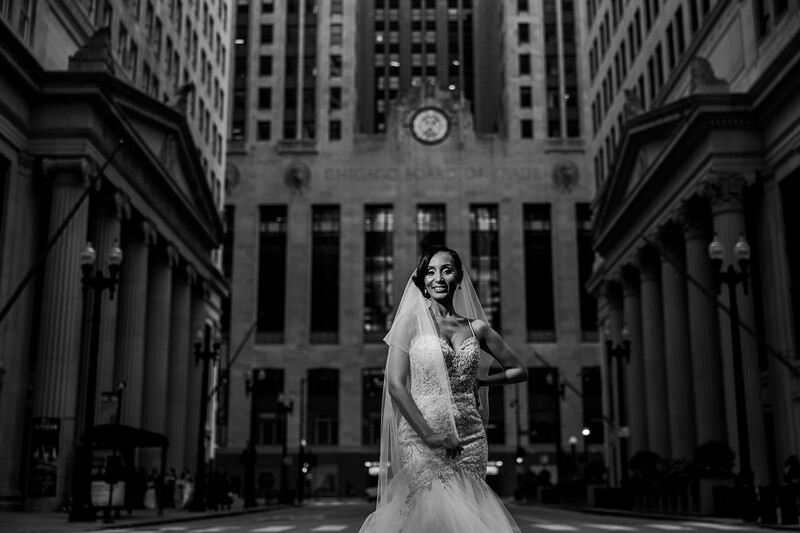 Bride stands in front of buildings in black and white