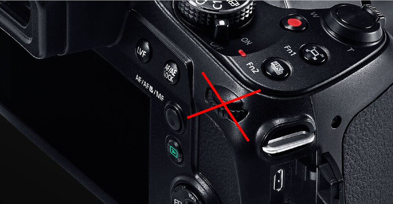 Close-up of a camera control panel with a red X marking overlaid on the center area.