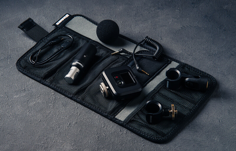 Professional audio and video recording equipment organized on a black equipment mat.