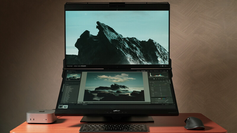 Laptop with dual monitors displaying landscape photography editing workflow with mountain and sky images.