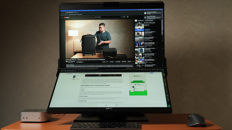 Dual-monitor setup displaying video editing software and web content on a wooden desk.