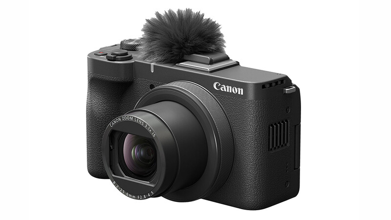 Canon PowerShot V10 compact camera with attached wireless microphone on top.
