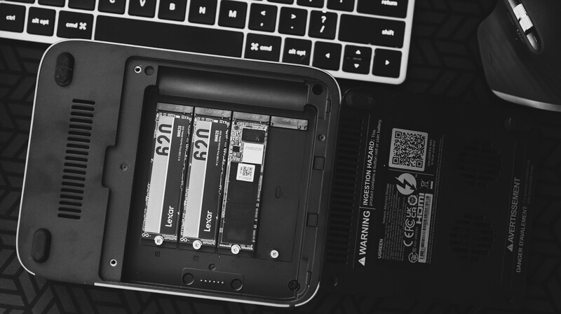 Laptop opened to show internal components including RAM modules and storage drives alongside keyboard and mouse.