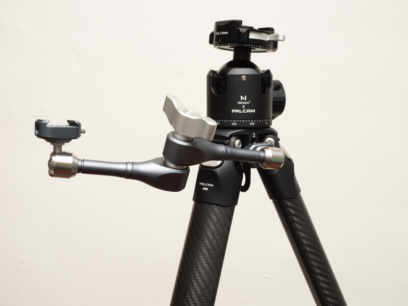 Professional ball head tripod with carbon fiber legs and quick-release plate against white background.