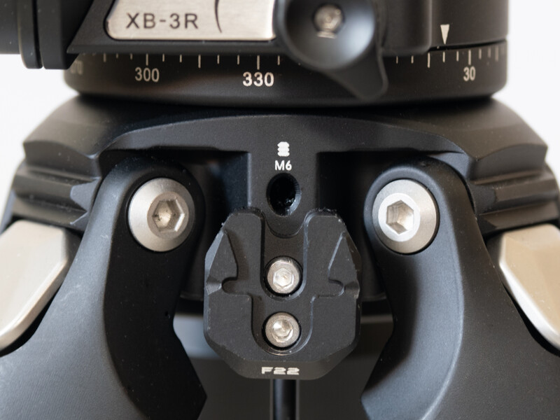 Top-down view of a tripod head with dual adjustment knobs and a panoramic scale marked from 300 to 330 degrees.