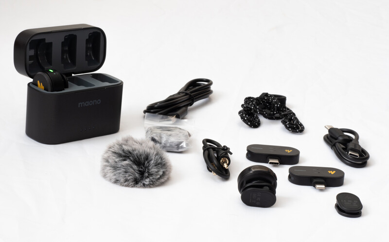 Complete wireless microphone system laid out with case, microphones, windscreen, cables, and accessories.