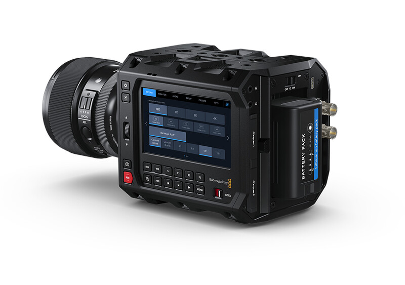 Professional digital cinema camera with large touchscreen display and attached lens shown against white background.
