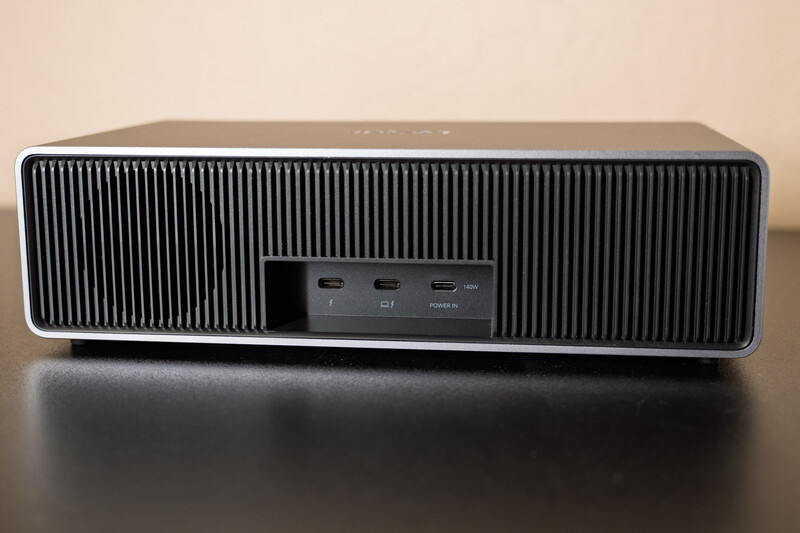 Modern portable speaker with vertical ribbed grille and control buttons on dark surface.