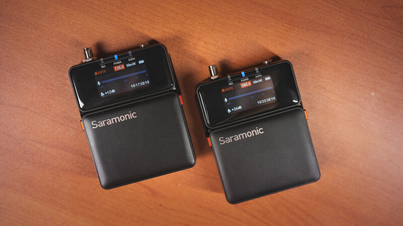 Two Saramonic wireless microphone receivers displayed side-by-side on an orange surface.