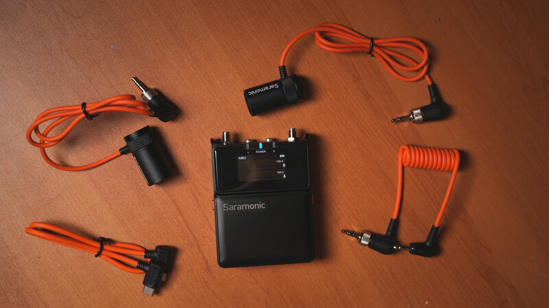 Saramonic wireless microphone system with receiver unit and multiple lavalier and handheld microphone capsules with orange cables.