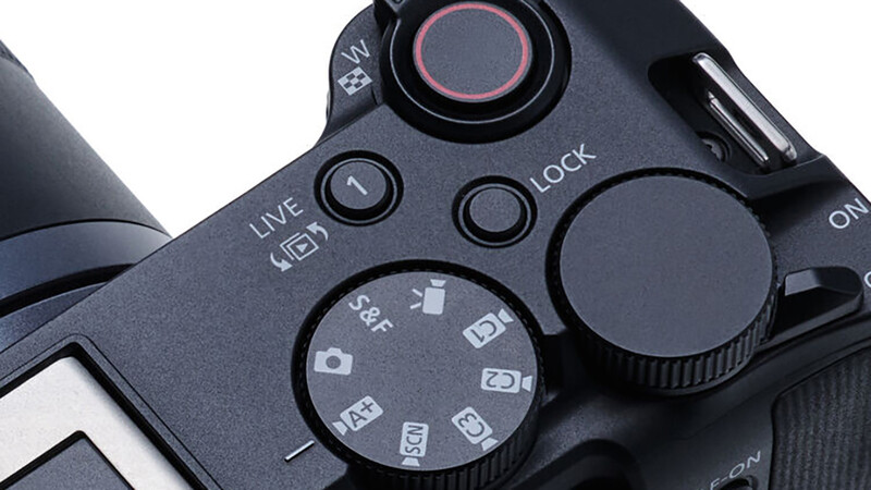 Close-up of camera control dial showing shooting modes including S, AF, and manual focus settings.