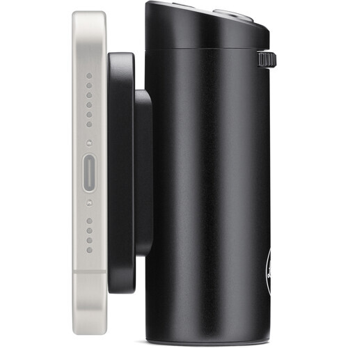 Side view of a cylindrical black camera lens with silver and black control rings and adjustment buttons.